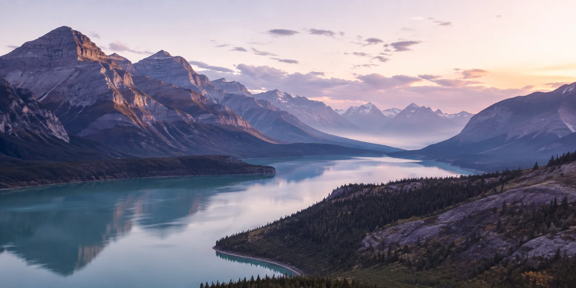 Layers of misty mountains reflected in a tranquil alpine lake