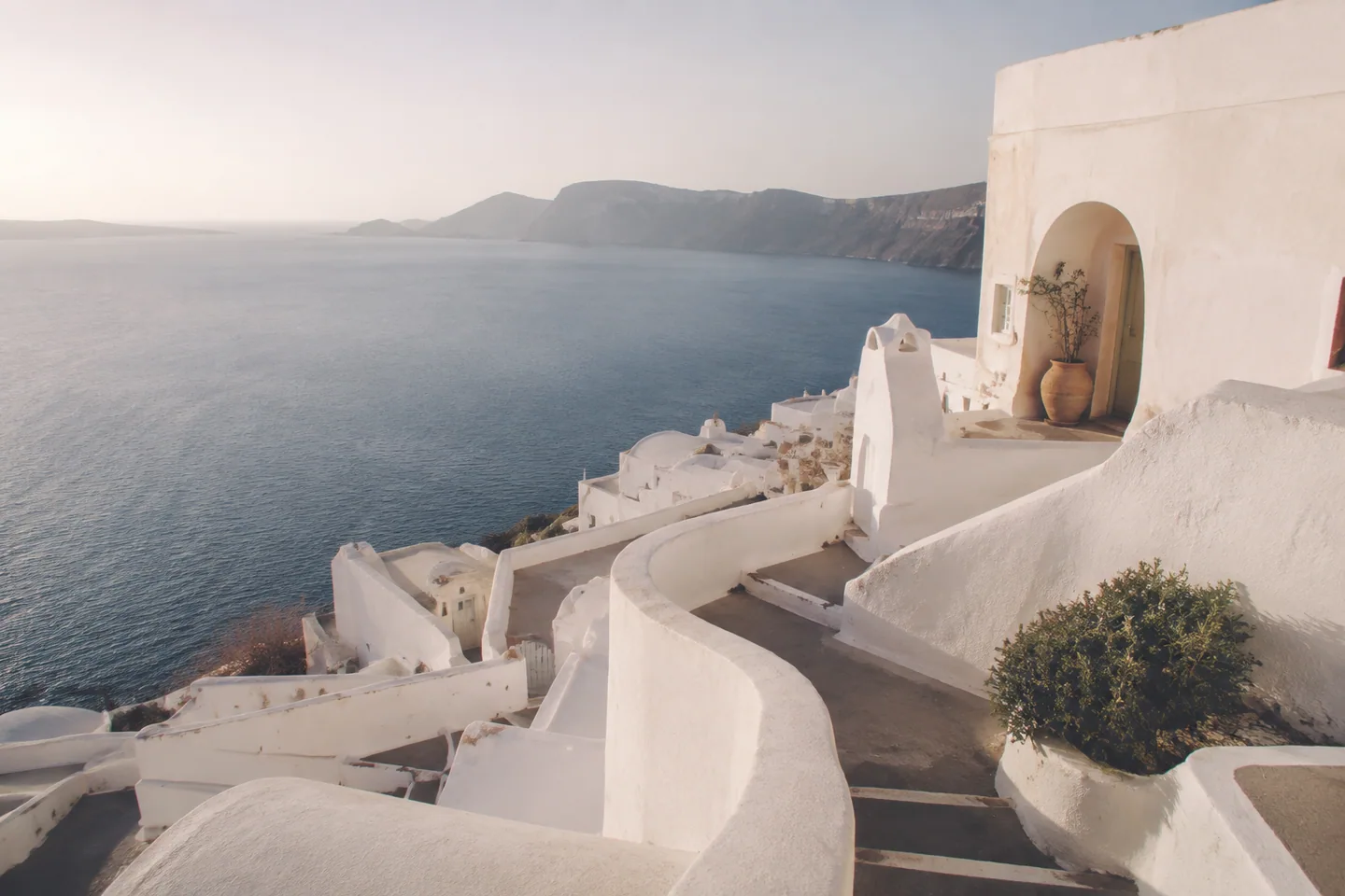 Whitewashed Santorini terraces above the still Aegean Sea